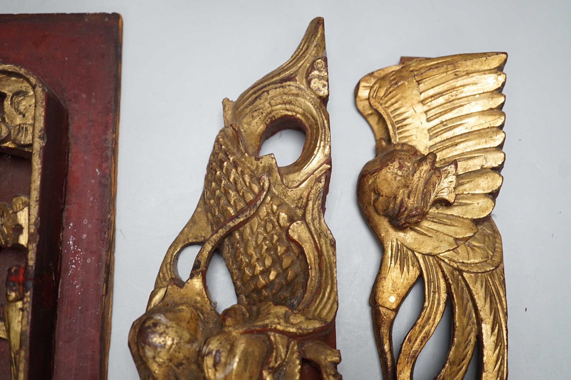 Three Chinese gilded and lacquered wood figural panels and two similar dragon and phoenix crest pieces (5), late 19th century
